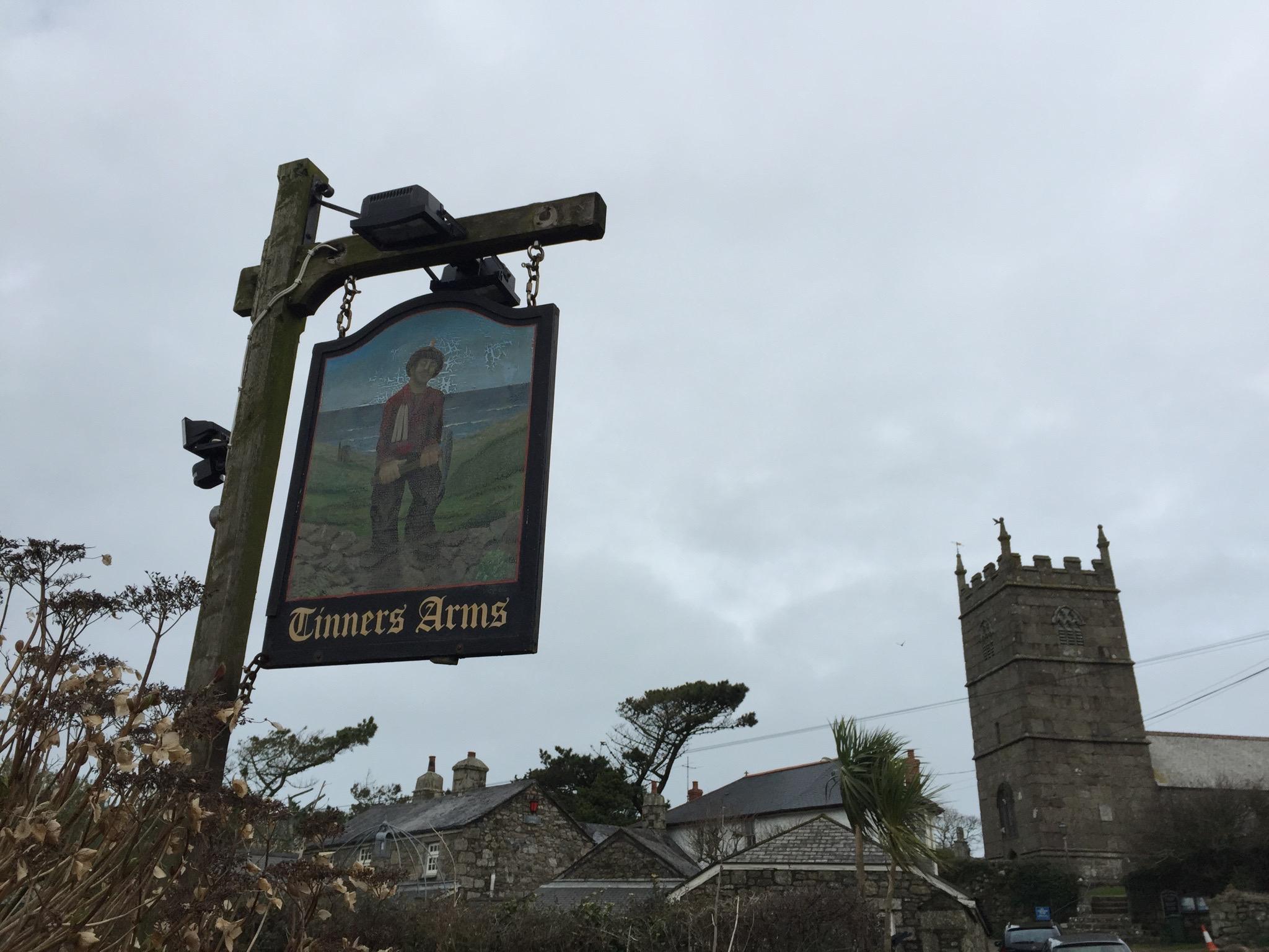 The Tinners Arms sign beside a Cornish village church